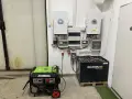 Instalacja fotowoltaiczna z falownikami, akumulatorami i agregatem prądotwórczym. System zapewnia niezawodne zasilanie.