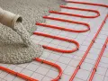 Wylewanie betonu na rury ogrzewania podłogowego. Zastanawiasz się, ile kosztuje worek cementu do takiej inwestycji?