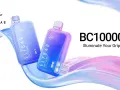 Dos vapers Elf Bar BC10000 en tonos azules y morados, uno con etiqueta "Blue Razz Ice", flotando sobre ondas de color.