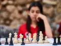 Niña pensativa frente a un tablero de ajedrez, inmersa en los juegos de decisiones.