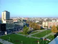 Widok na centrum Kragujevac Serbia z budynkami mieszkalnymi, parkiem i ulicą pełną samochodów.