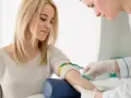 Pielęgniarka pobiera krew od pacjentki. Wyniki badań wskazują na rdw-cv podwyższone, co może sugerować niedobór żelaza.