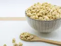 Un cuenco lleno de soja texturizada y una cuchara de madera con más de este ingrediente versátil.