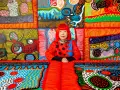 Yayoi Kusama, entourée de son univers psychédélique, une explosion de couleurs vives et de pois emblématiques.