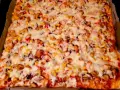 Pyszny przepis na pizzę z kurczakiem, kukurydzą i pieczarkami, obficie posypaną ciągnącym się serem.