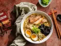 Jak zrobić ramen? Aromatyczny bulion, makaron, jajko na pół, plastry mięsa i nori. Obok paczka goździków Prymat.