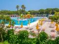 Słoneczny dzień w Portofelice Camping Village. Baseny, zjeżdżalnie i leżaki czekają na gości.
