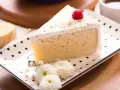 Pyszny kawałek ciasta Tres Leches, udekorowany maliną i cynamonem, czeka na spróbowanie. Idealny przepis na deser.