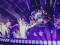 Tancerze w białych strojach i błyszczących kreacjach na scenie podczas koncertu Havasi Symphonic.
