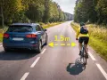 En bil kör nära en cyklist på en landsväg i Sverige. Texten "1,5m" indikerar avståndet mellan dem.