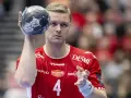 Aron Palmarsson, zawodnik z numerem 4 na czerwonej koszulce, trzyma piłkę do piłki ręcznej, gotowy do rzutu.