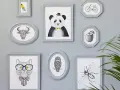 En samling gråa ramar med djur och föremål. En panda med fluga, en tjur, en katt med glasögon, en uggla, en bi, ett äpple och en cykel. Någon har valt att måla ramar för att skapa en personlig vägg.