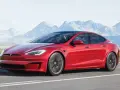 Czerwony Tesla Model S jedzie po drodze, a w tle widać góry. Tesla co to? To przyszłość motoryzacji.
