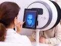 Lekarz analizuje obraz twarzy pacjenta na tablecie, wykorzystując zaawansowane urządzenie do diagnostyki chorób skóry.