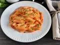 Penne cremose con un sugo rosa, arricchito dal gusto del philadelphia, guarnite con prezzemolo fresco.