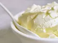 Kremowa masa w białej miseczce, idealna jako zamiennik mascarpone do deserów.