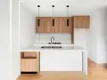 Cocinas pequeñas con barra, minimalistas y modernas, con gabinetes de madera y encimera blanca.