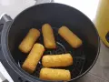Crocchette di patate dorate e croccanti pronte per essere gustate, appena uscite dalla friggitrice ad aria.