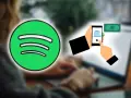 Spotify-Logo neben einer Hand, die ein Smartphone mit Bank-Symbol und Geldschein hält. Dies illustriert Spotify-Zahlungsmethoden.