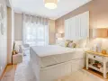 Camera da letto accogliente con letto bianco, comodino con libri e lampada. Idee su cosa mettere su como camera da letto.