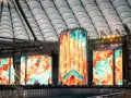 Wielkie ekrany rozświetlają stadion, tworząc barwną mozaikę. To roztanczony narodowy transmisja, gdzie sztuka i muzyka łączą się w widowiskowym spektaklu.