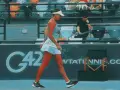 Tenisistka idzie po korcie, trzymając rakietę. Tło sugeruje turniej WTA Abu Dhabi 2026.