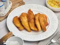 Knuspriges Wiener Backhendl, original Rezept. Goldbraun paniert und perfekt gegart, daneben Kartoffelsalat.