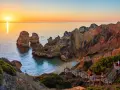 Zachód słońca nad skalistym wybrzeżem Algarve. Portugalia, jakie morze? To Atlantyk, który tworzy tu malownicze zatoczki i łuki skalne.