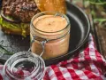 Ein Glas mit selbstgemachter Burgersauce steht neben einem Burger. Perfekt zum burgersauce selber machen!