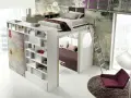 Arredamenti camerette moderni: letto soppalcato con libreria integrata e zona relax sottostante, scala a pioli, poltrona e tappeto.