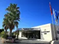 Wejście do Mandarin Resort Hotel z palmami i flagami. Wiele pozytywnych mandarin resort opinie potwierdza jego urok.