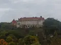 Zamek na wzgórzu, otoczony jesiennym lasem, przypomina o historii Krakowa i Kalwarii Zebrzydowskiej.