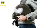 Un motociclista tiene un casco nero lucido e guanti. Scopri come pulire visiera casco per una guida sicura.