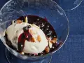 Cremiges Malaga Eis Rezept mit Blaubeersauce und Mandelsplittern in einer Glasschale.