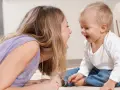 Frau und Baby lachen sich an. Sie unterhalten sich, zahlen ohne Sorgerecht, aber die Freude ist echt.
