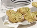 Zucchini Schnecken mit Käsefüllung auf einem Teller mit weißer Serviette.