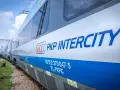 Pociąg PKP Intercity z niebieskim pasem i logo.