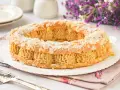 Un delicioso praliné que es un pastel Paris-Brest, cubierto de almendras laminadas y espolvoreado con azúcar glas.