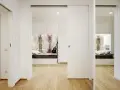 Un letto a scomparsa e una porta scorrevole creano una stanza in più, trasformando un corridoio in uno spazio accogliente.