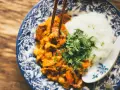 Miseczka z ryżem i curry, podana z posiekaną natką pietruszki, jedzona pałeczkami.