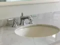 Lavandino in marmo poroso con rubinetteria cromata. Per sapere come pulire il marmo poroso, guarda questo bagno elegante.