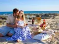 Romantyczny piknik na plaży podczas wakacji na Cyprze. Para cieszy się chwilą przy winie i owocach, z widokiem na morze.