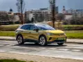 Żółty VW ID.4 jedzie po mieście, pokazując swój imponujący zasięg.
