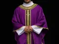 Eleganckie fioletowe szaty liturgiczne z bogatymi złotymi zdobieniami, noszone przez mężczyznę z dłońmi złożonymi na piersi.