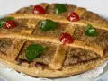 Tarta de Mondoñedo, un dulce tradicional con masa dorada, relleno de frutos secos y decorada con cerezas rojas y verdes.