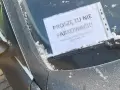 Na przedniej szybie samochodu, pokrytej szronem, widnieje kartka z napisem "Proszę tu nie parkować!!! Parking tylko dla mieszkańców bloku".