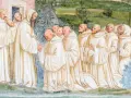 A bearded monk greets a line of novices, their white robes hinting at a rich monk history.