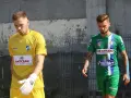 Dwóch piłkarzy, w tym Michał Kaszuba w żółtej koszulce bramkarza, idzie obok siebie.
