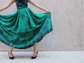 Abito color ottanio con fantasia di alberi. Scarpe nere eleganti completano il look.
