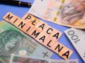 Płaca minimalna brutto na tle polskich banknotów.
